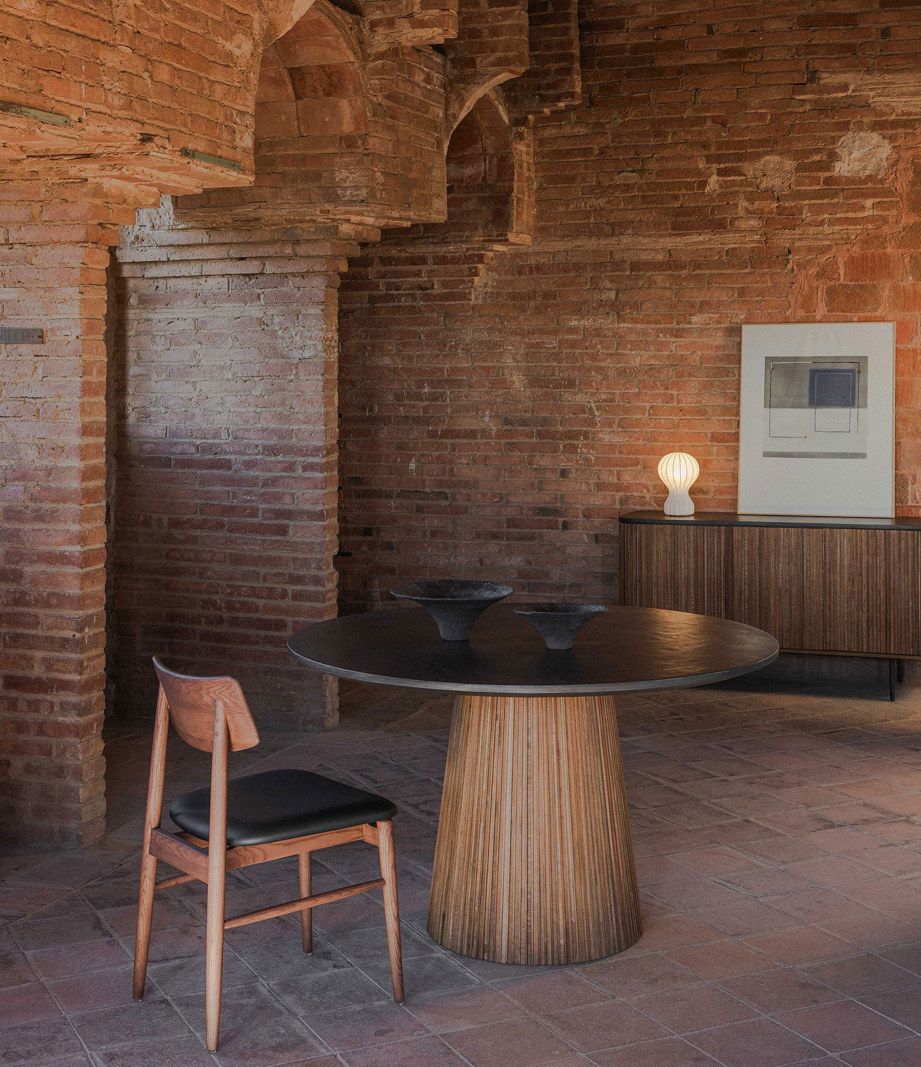 ambiente-aparador-mesa-redonda-130-kirei-antracita-silla-varma-fresno-piel-negra-lampara-sobremesa-gatto-flos-pilma